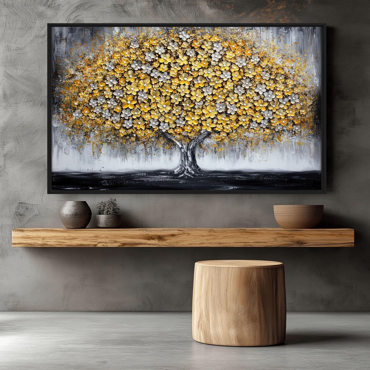 Yellow and gray tree artwork above a wood shelf and round stool against a gray wall